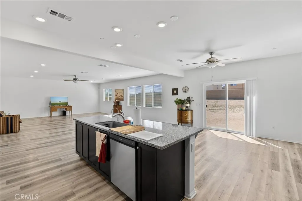 12487 Sunset Road Victorville, CA 92392 - Photo 19 of 44 a kitchen with stainless steel appliances granite countertop a sink stove and wooden floor