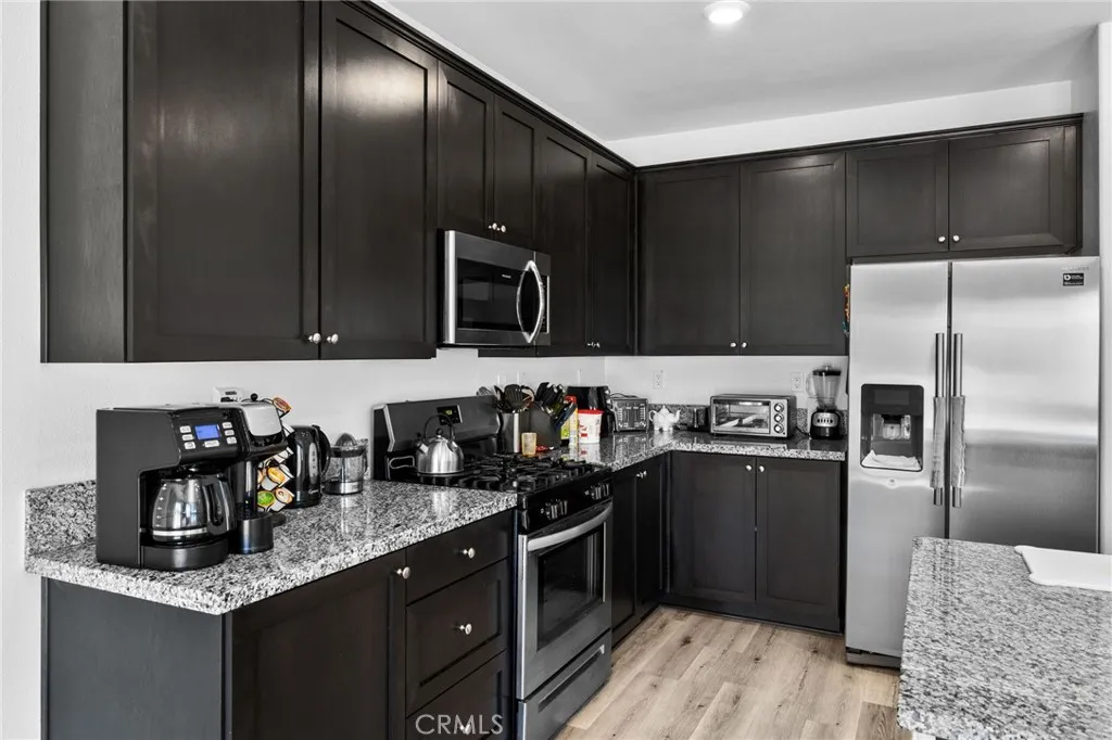 12487 Sunset Road Victorville, CA 92392 - Photo 20 of 44 a kitchen with granite countertop stainless steel appliances and wooden cabinets