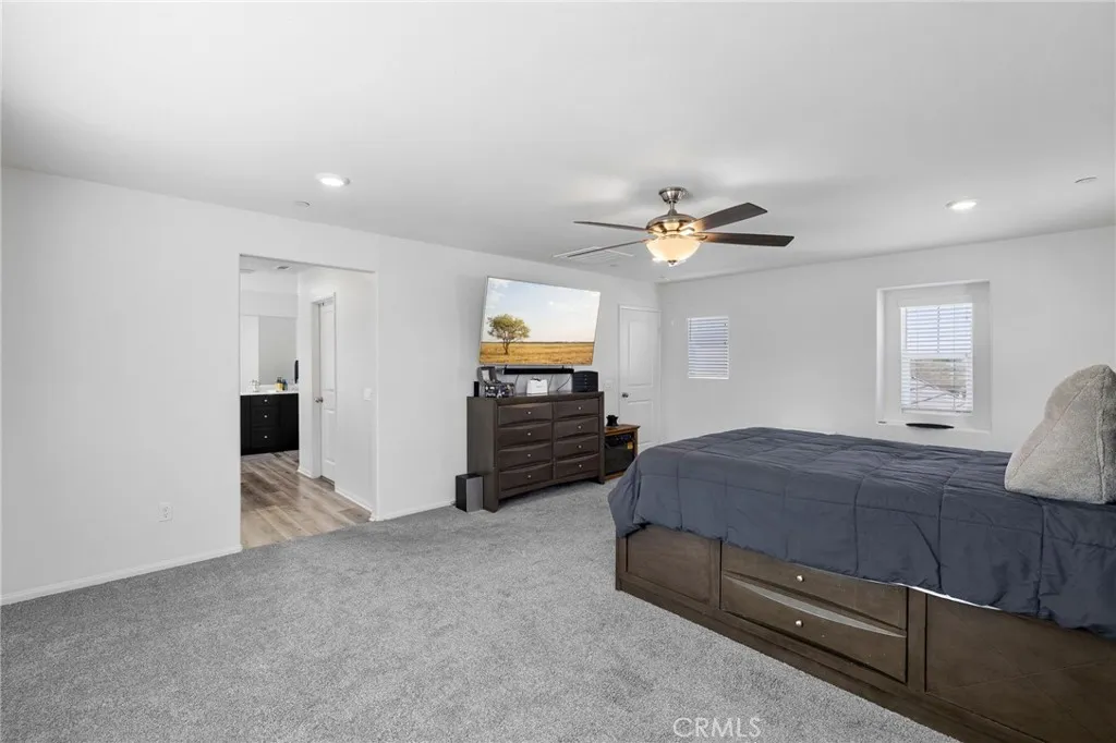 12487 Sunset Road Victorville, CA 92392 - Photo 29 of 44 a bedroom with a bed and a chandelier
