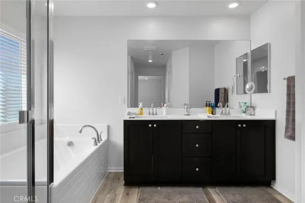 a en suite bathroom with a double vanity sink a mirror and a shower