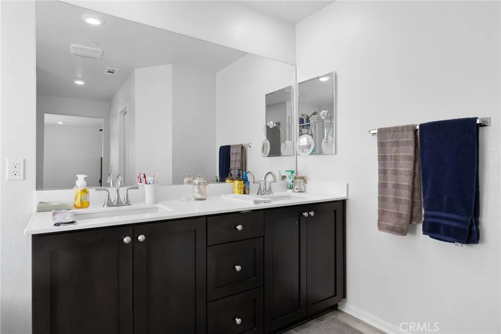 12487 Sunset Road Victorville, CA 92392 - Photo 33 of 44 a en suite bathroom with a double vanity sink a mirror and a shower