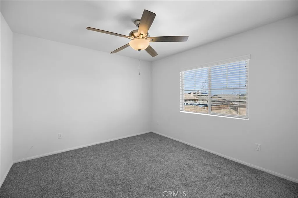12487 Sunset Road Victorville, CA 92392 - Photo 36 of 44 an empty room with windows and fan