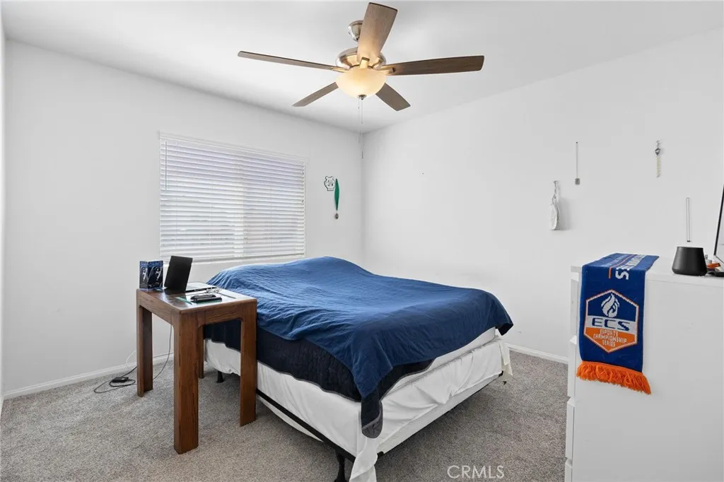 12487 Sunset Road Victorville, CA 92392 - Photo 38 of 44 a bedroom with a bed and a table in it