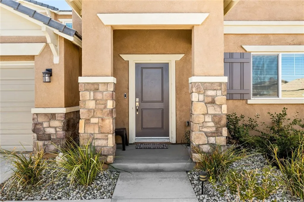 12487 Sunset Road Victorville, CA 92392 - Photo 5 of 44 a front view of a house with a garden