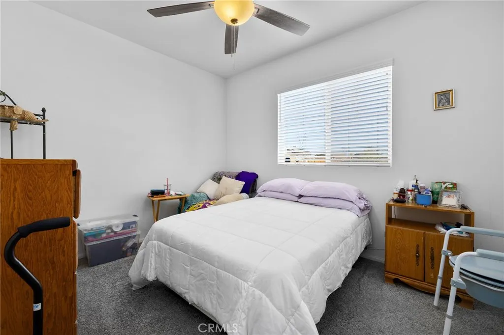 12487 Sunset Road Victorville, CA 92392 - Photo 8 of 44 a bedroom with a bed and a chandelier