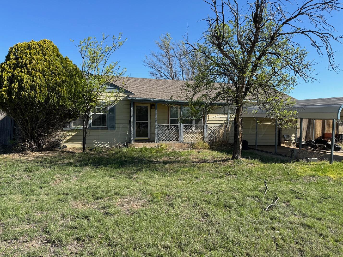 a view of a house with backyard and a tree