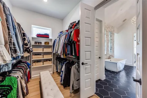 a view of walk in closet with clothes and shoes