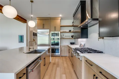 a kitchen with stainless steel appliances granite countertop a sink stove and refrigerator