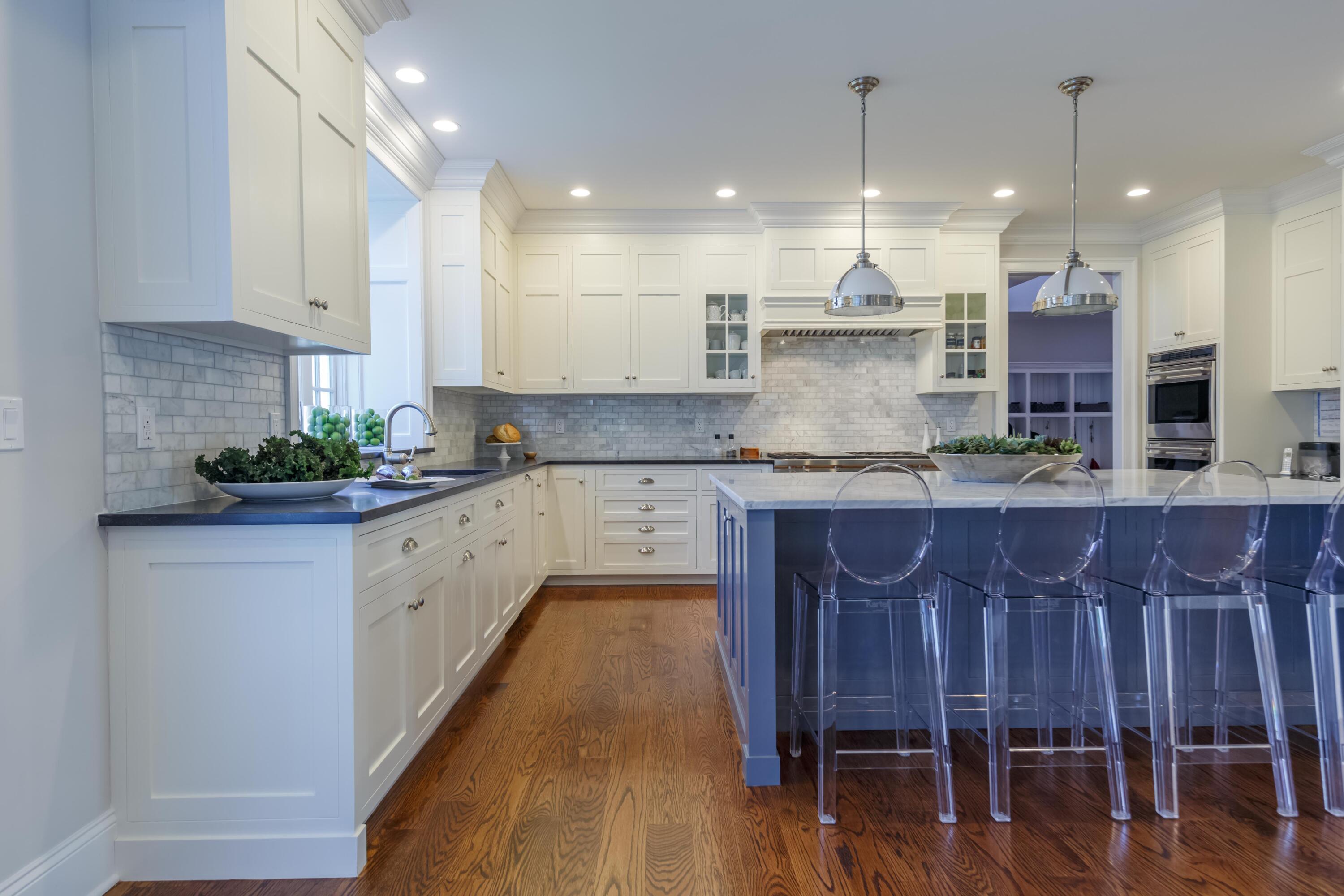 275 Middlesex Road Darien, CT 06820 - Photo 20 of 64 a large kitchen with kitchen island granite countertop a stove a sink a refrigerator and white cabinets with wooden floor