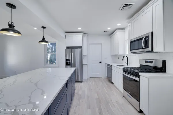a kitchen with granite countertop a sink and a stove top oven