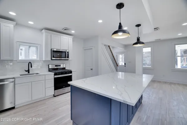 a kitchen with appliances a sink and cabinets