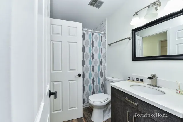 a bathroom with a sink vanity mirror and toilet