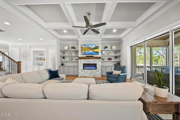 a living room with fireplace furniture and a large window