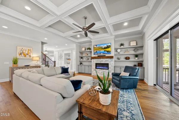 a living room with furniture a flat screen tv and a table