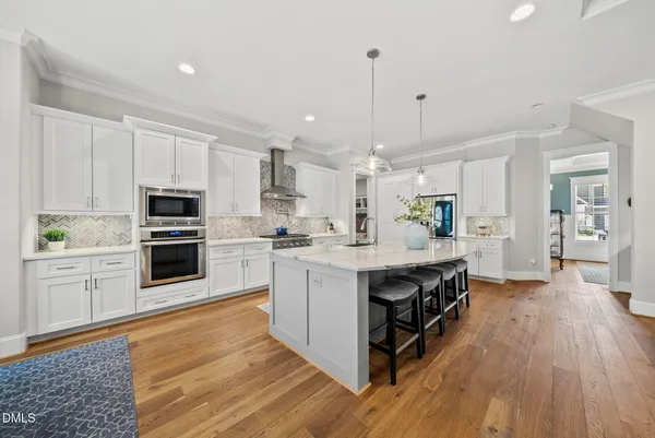 a large kitchen with stainless steel appliances sink stove and cabinets