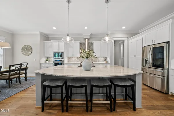 a kitchen with kitchen island a dining table and chairs