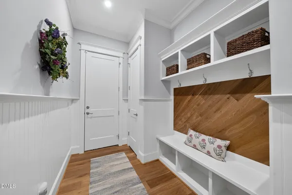 a hallway with wooden floor and a potted plant