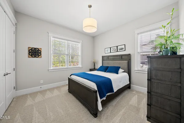 a bedroom with a bed and a potted plant