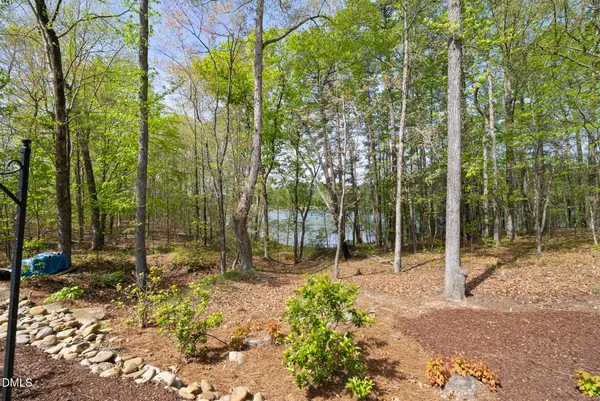 a view of a house with a big yard and large trees