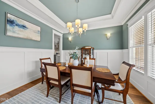 a dining room with furniture a chandelier and wooden floor