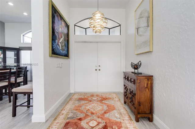 a kitchen with stainless steel appliances kitchen island granite countertop a stove a sink a refrigerator and white cabinets with wooden floor