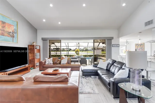 a dining room with furniture a large window and a chandelier