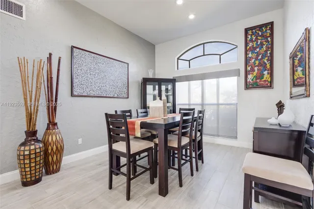 a very nice looking living room with a large window and dining table