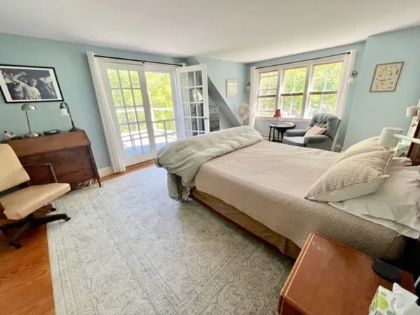 a spacious bedroom with a bed and glass window