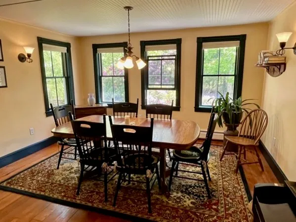 a view of a a dining room with furniture window and wooden floor