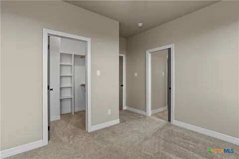 an empty room with closet and a hallway