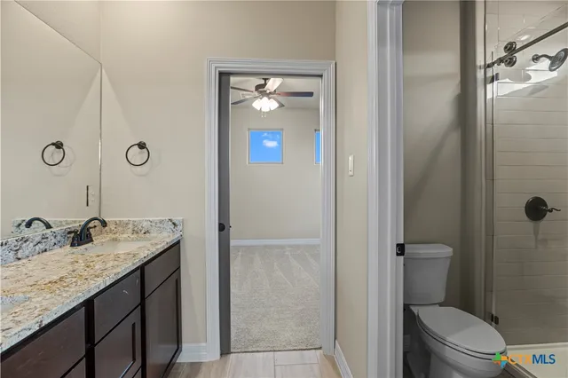 a bathroom with a granite countertop sink toilet and shower