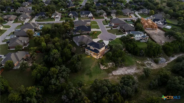 an aerial view of residential house with outdoor space and trees all around