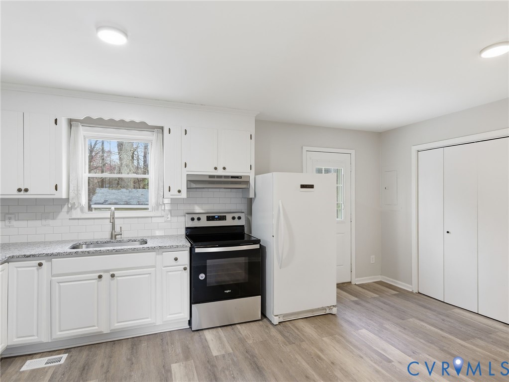 3626 Gilbert Street Hopewell, VA 23860 - Photo 7 of 20 a kitchen with granite countertop a refrigerator a sink and wooden floors