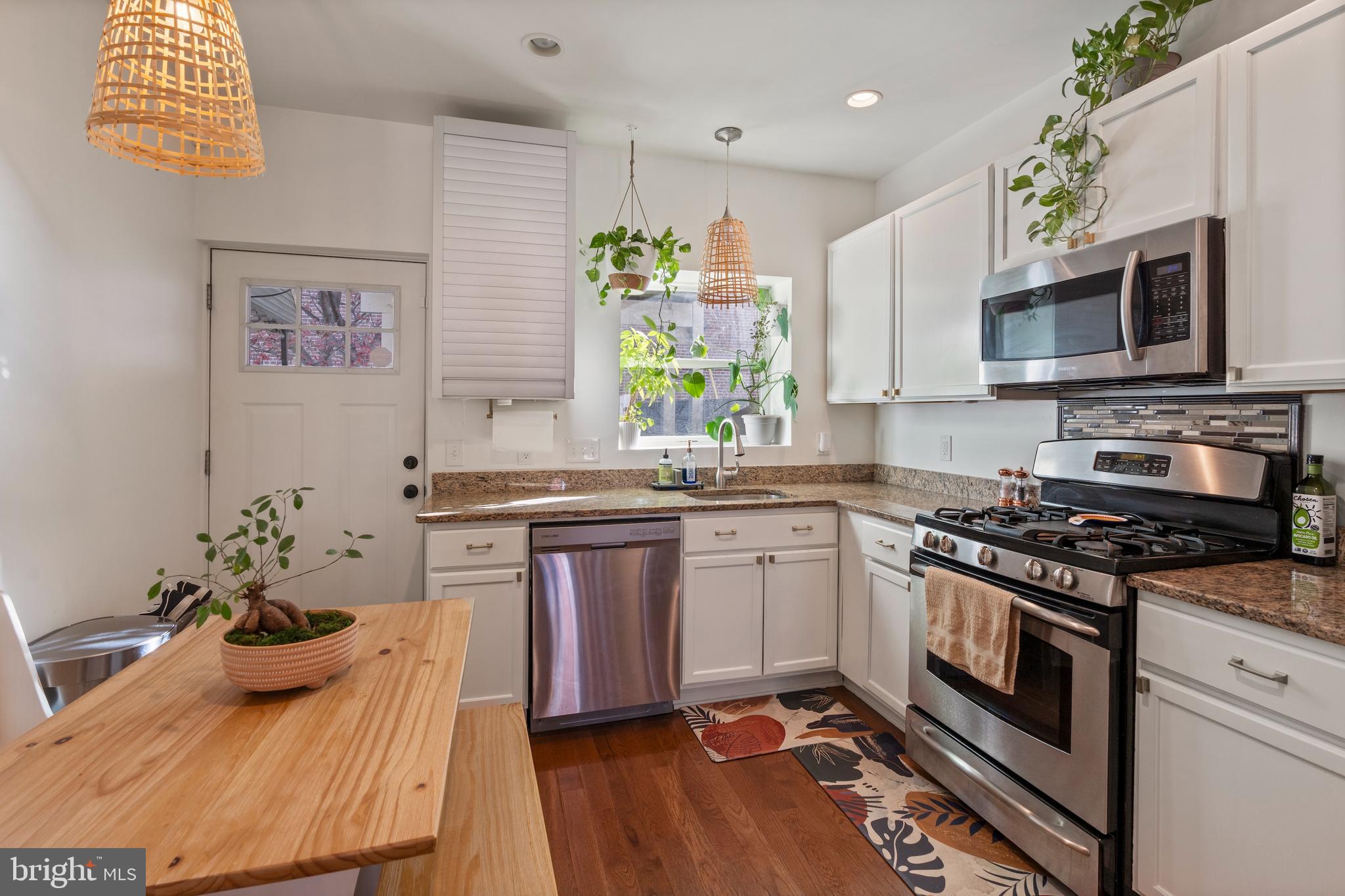 431 South Robinson Street Baltimore, MD 21224 - Photo 5 of 29 a kitchen with stainless steel appliances kitchen island granite countertop a stove a sink and a microwave