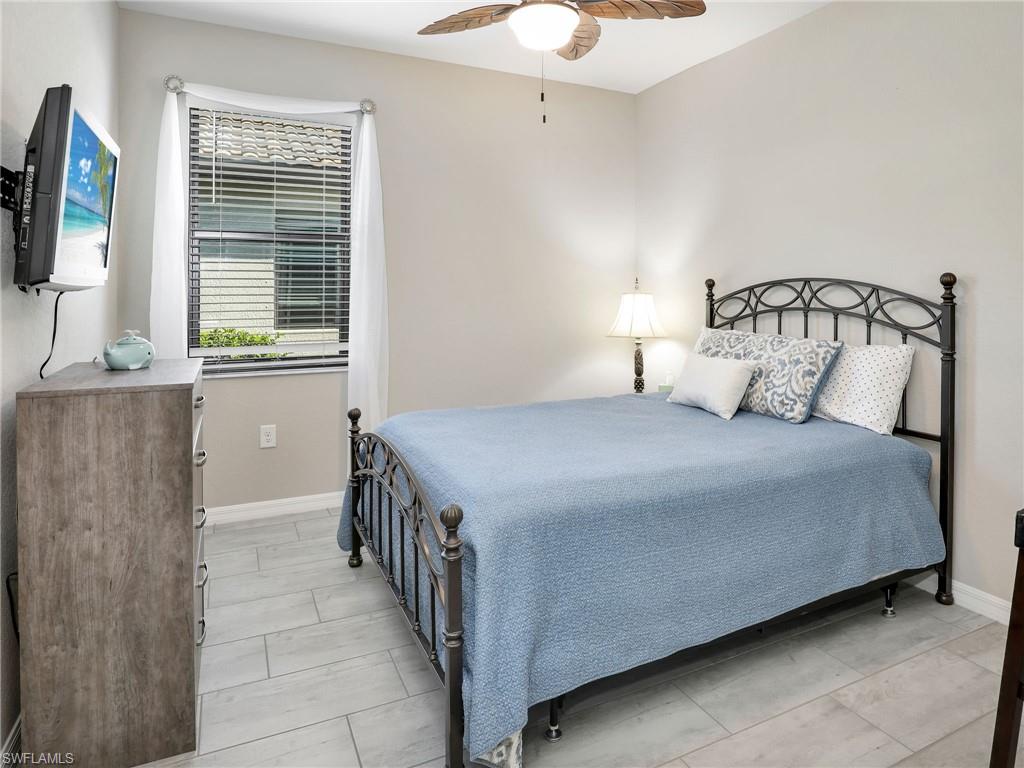 17528 Ashcomb Way Estero, FL 33928 - Photo 21 of 42 a bedroom with a bed and a flat tv screen on dresser