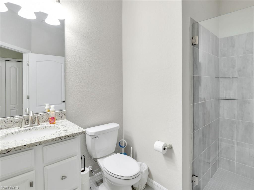 17528 Ashcomb Way Estero, FL 33928 - Photo 22 of 42 a bathroom with a granite countertop toilet sink and a mirror