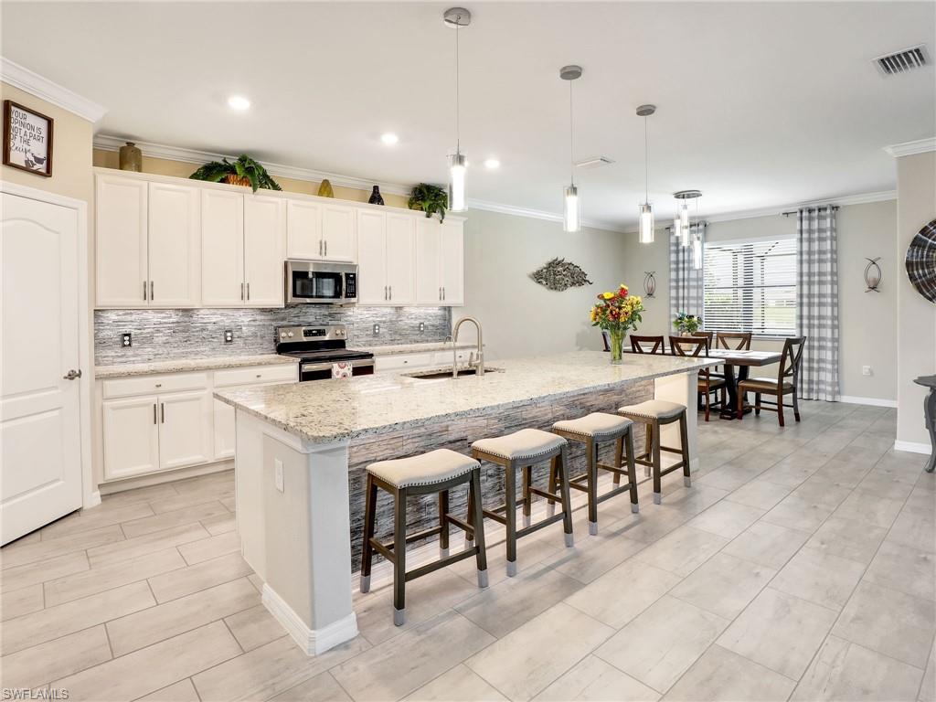 17528 Ashcomb Way Estero, FL 33928 - Photo 4 of 42 a kitchen with appliances a sink a counter top space and cabinets