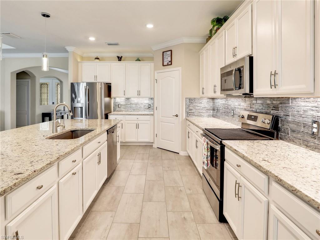 17528 Ashcomb Way Estero, FL 33928 - Photo 5 of 42 a large kitchen with stainless steel appliances lots of counter space sink and cabinets
