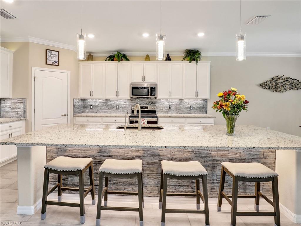 17528 Ashcomb Way Estero, FL 33928 - Photo 7 of 42 a kitchen with cabinets and chairs in it