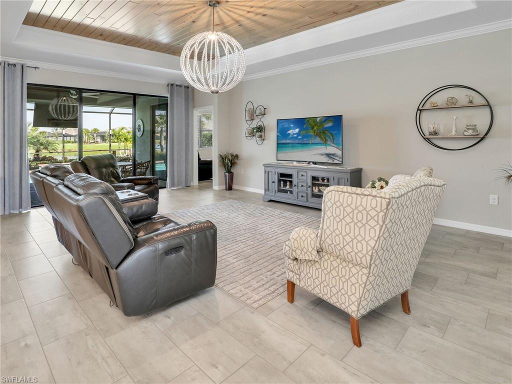 17528 Ashcomb Way Estero, FL 33928 - Photo 8 of 42 a living room with furniture a large window and a chandelier