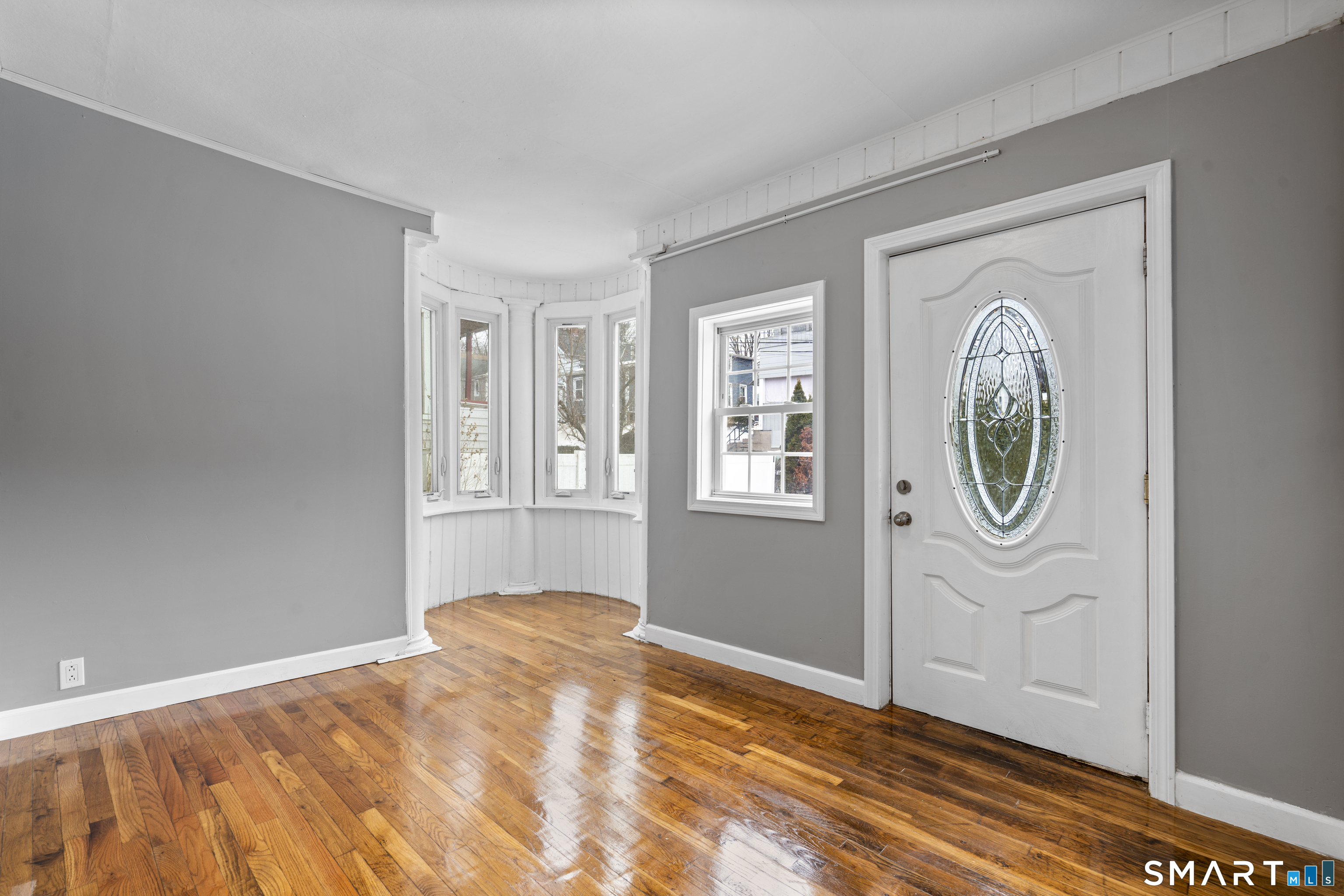 171 Foster Street Meriden, CT 06451 - Photo 5 of 35 a view of an empty room with window and wooden floor