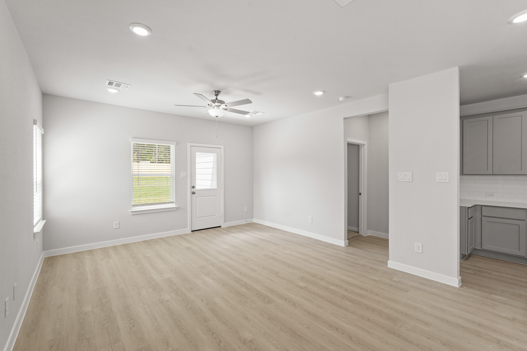 217 Spring Drive Hockley, TX 77447 - Photo 7 of 27 a view of an empty room with a window and wooden floor