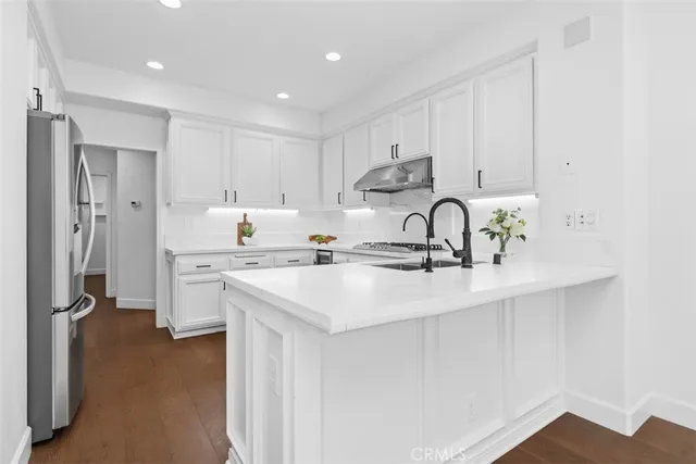 a kitchen with kitchen island a sink stainless steel appliances and cabinets