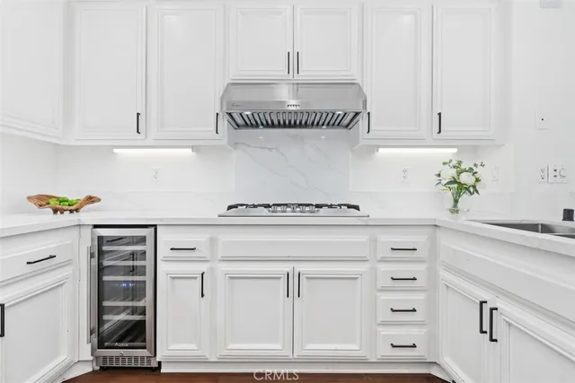 a kitchen with white cabinets and appliances