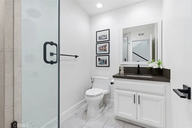 a bathroom with a toilet sink vanity and mirror