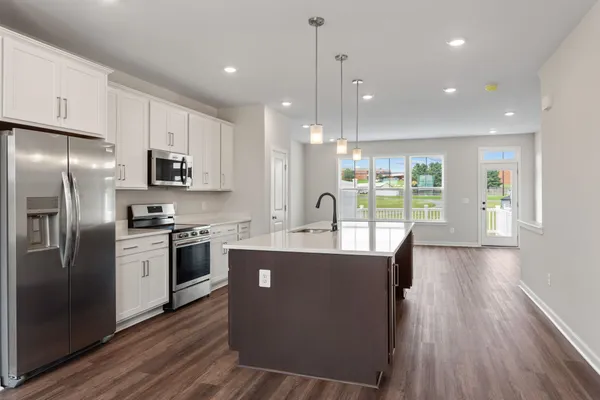 a kitchen with stainless steel appliances granite countertop a refrigerator a stove a sink and a microwave