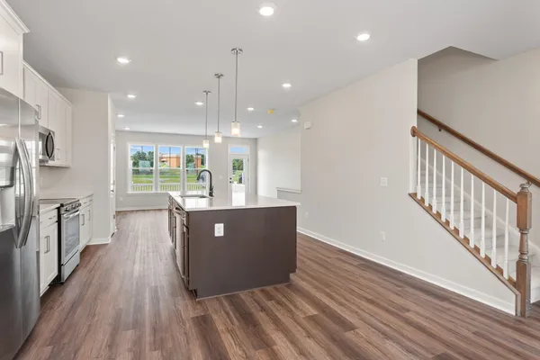 a view of kitchen and kitchen with stainless steel appliances wooden floor