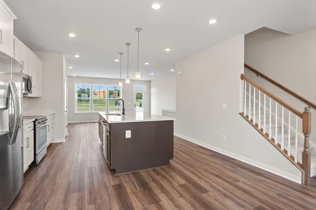a view of kitchen and kitchen with stainless steel appliances wooden floor