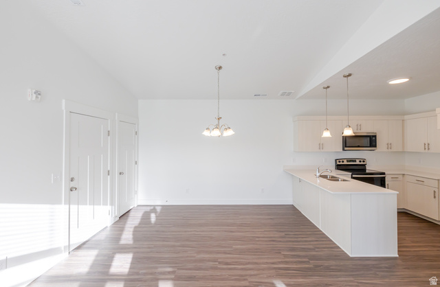 4662 Poplar Way, Unit Q302 Mapleton, UT 84664 - Photo 16 of 17 Kitchen featuring white cabinetry, stainless steel appliances, a peninsula, dark wood finished floors, and a chandelier