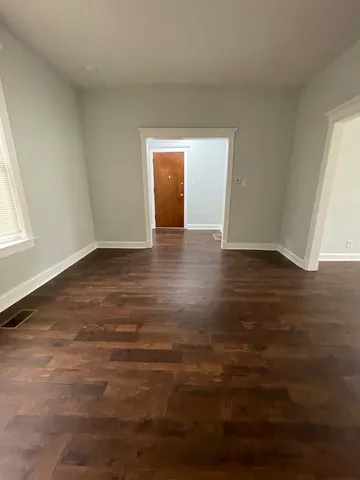 an empty room with wooden floor and closet